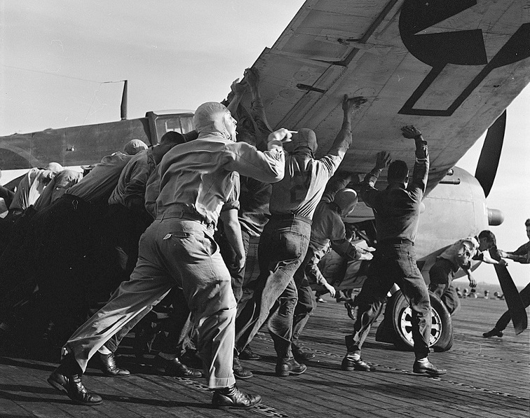 Crewmen aboard USS Lexington move a damaged plane 8″x 10″ World War II Photo 493